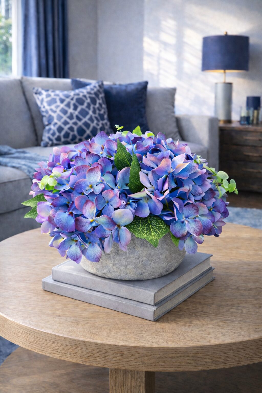 Blue and purple faux hydrangea arrangement in a stone bowl