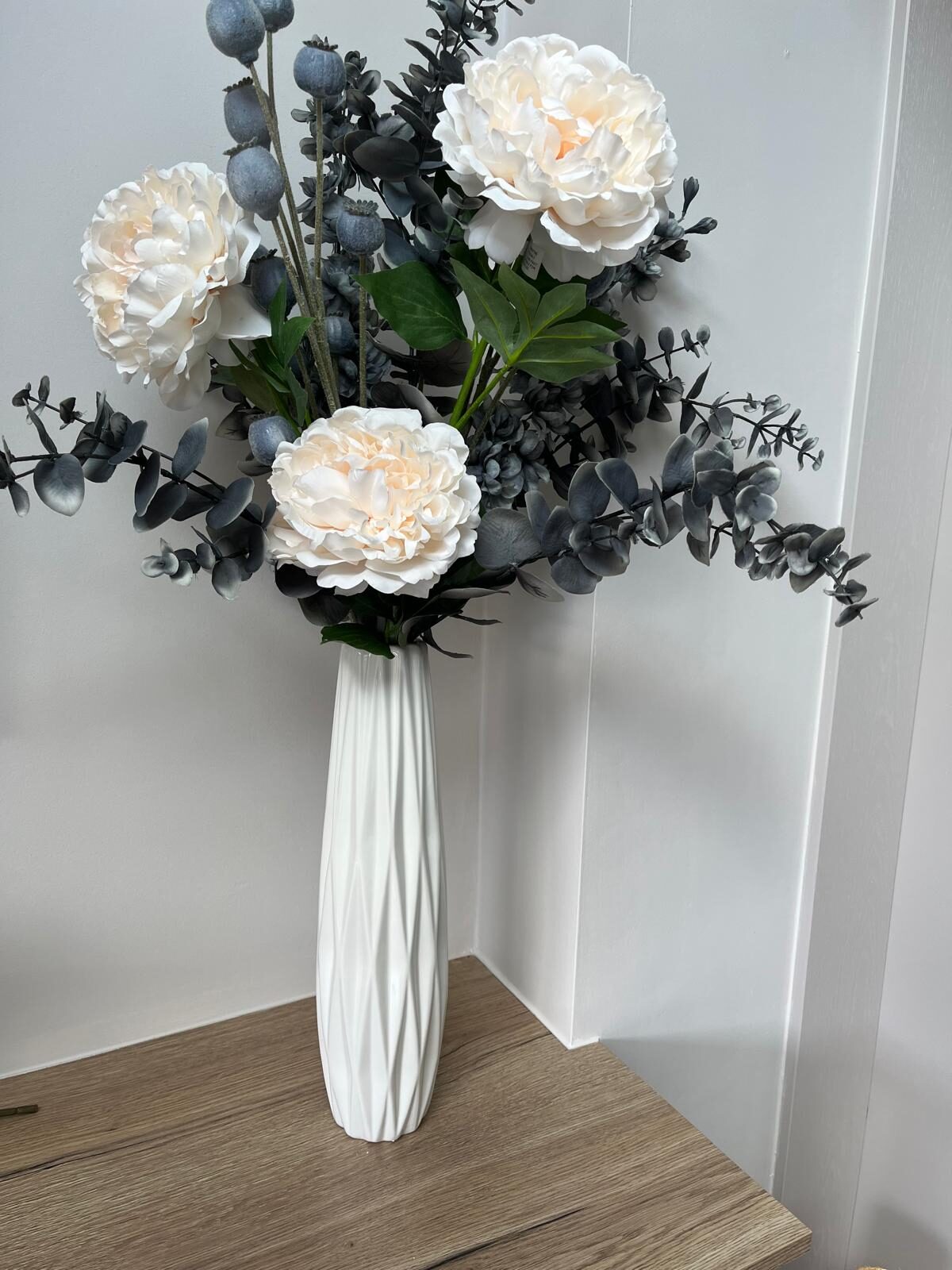 Blush silk peony faux arrangement with smoke-grey eucalyptus and poppy heads in a white vase