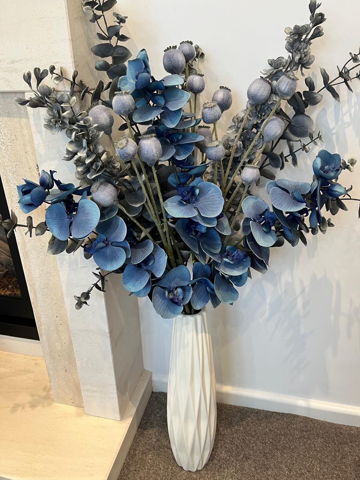 Blue silk orchid arrangement with poppy heads